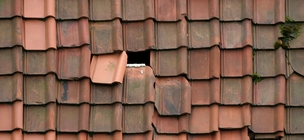 Töredezett kerámiacserepek javításra váró tetőn