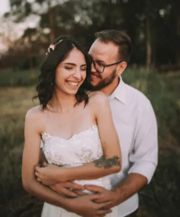 Boldog, mosolygó jegyespár fotózás közben.