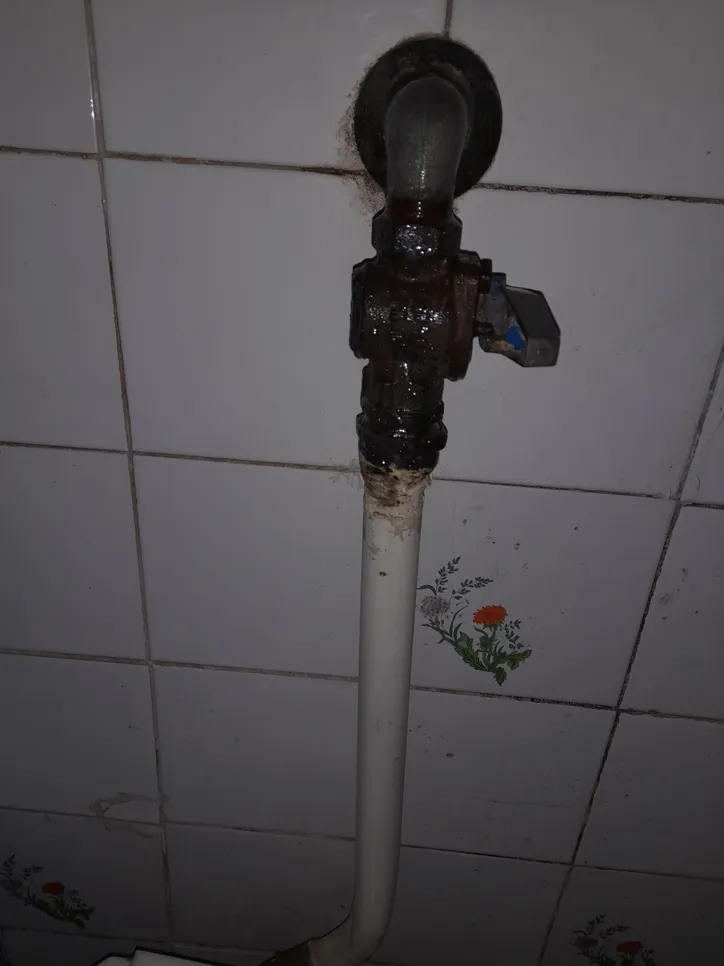 Rusty bathroom water pipe with leakage (9550) Corroded water pipe with visible rust and possible leakage in bathroom setting, tiled background.