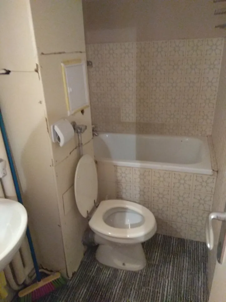 Kompakt fürdőszoba elcsúszott wc-vel (18824) Kis fürdőszoba, amelyben a WC a fürdőkáddal szomszédos, kiemelve a térkihasználási problémákat.