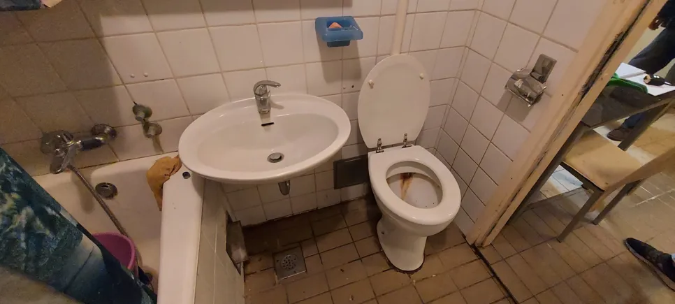 Kis fürdőszoba mosdóval a wc közelében (88991) Kompakt fürdőszoba, amelyben a mosdó és a WC szoros közelségben helyezkedik el, kiemelve a korlátozott teret és a rendetlenséget.